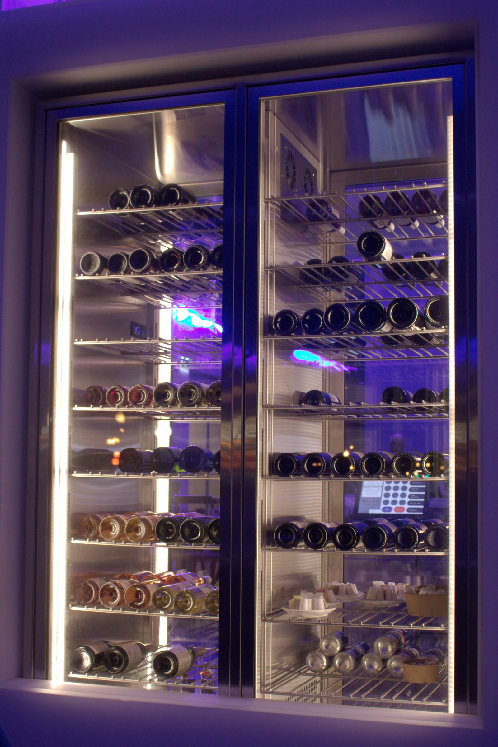 Monogram undercounter beverage center stocked with chilled drinks — certified Monogram beverage center service