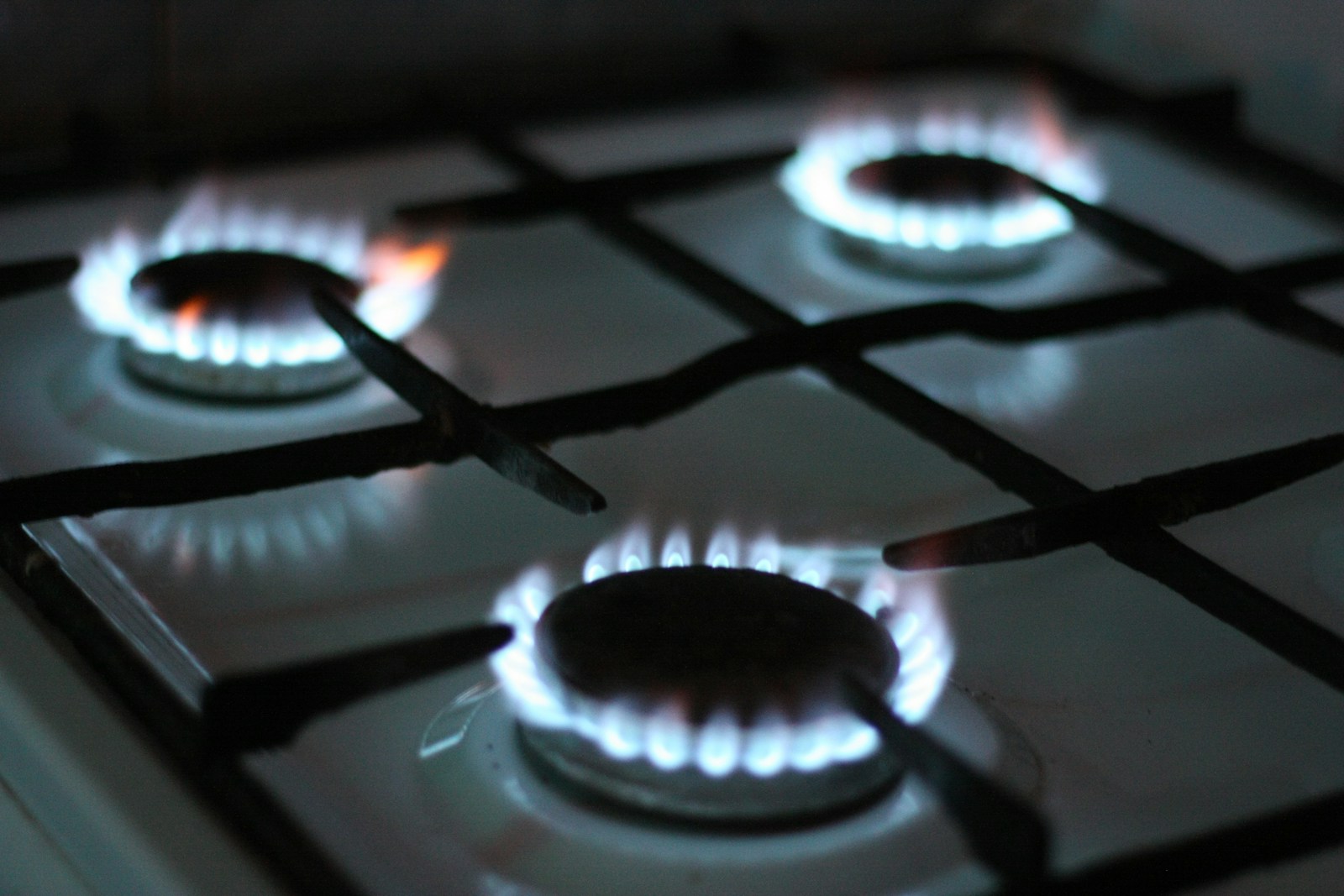 Monogram gas cooktop with blue flames on cast-iron grates — certified Monogram cooktop service